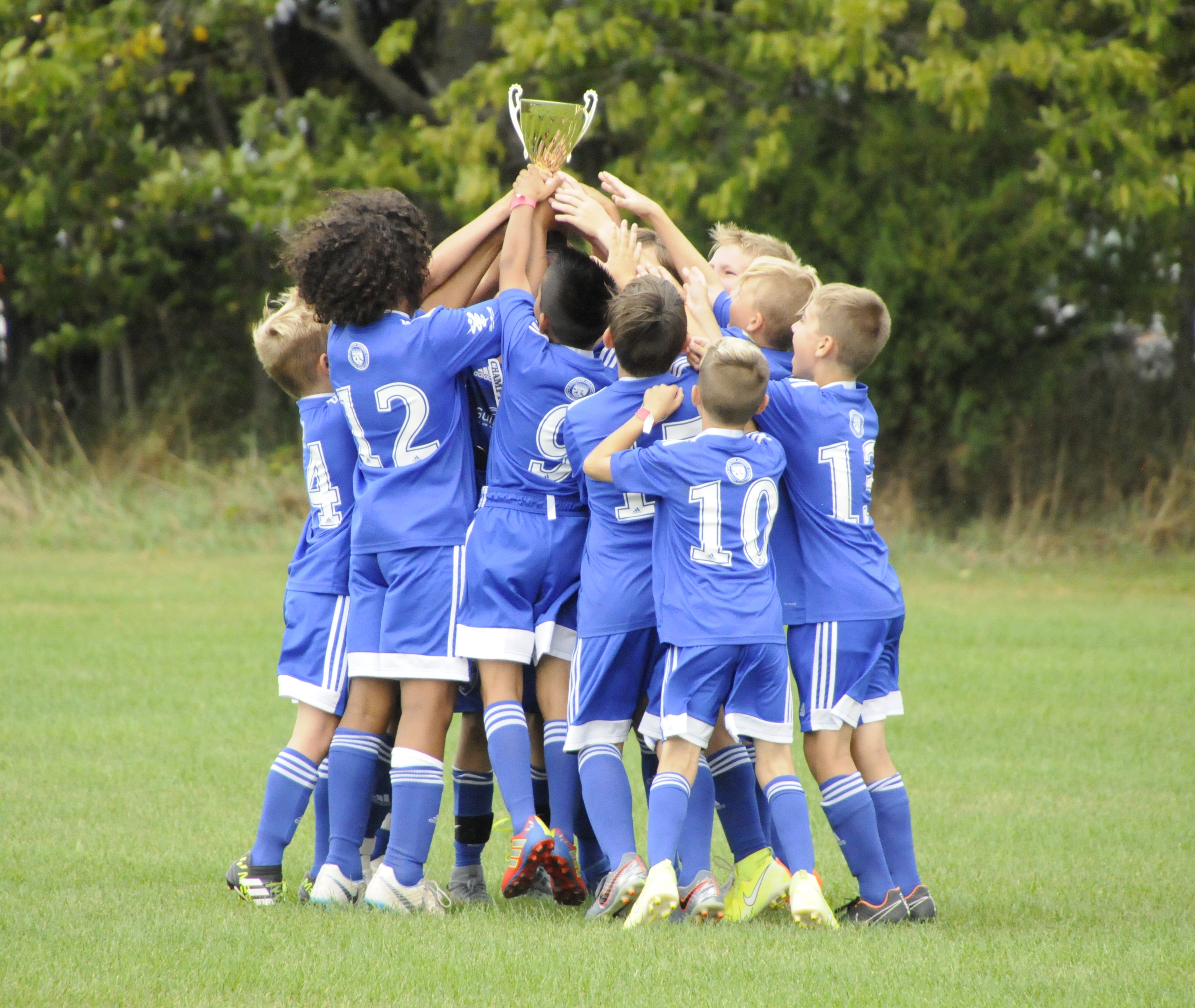 team raising tournament trophy